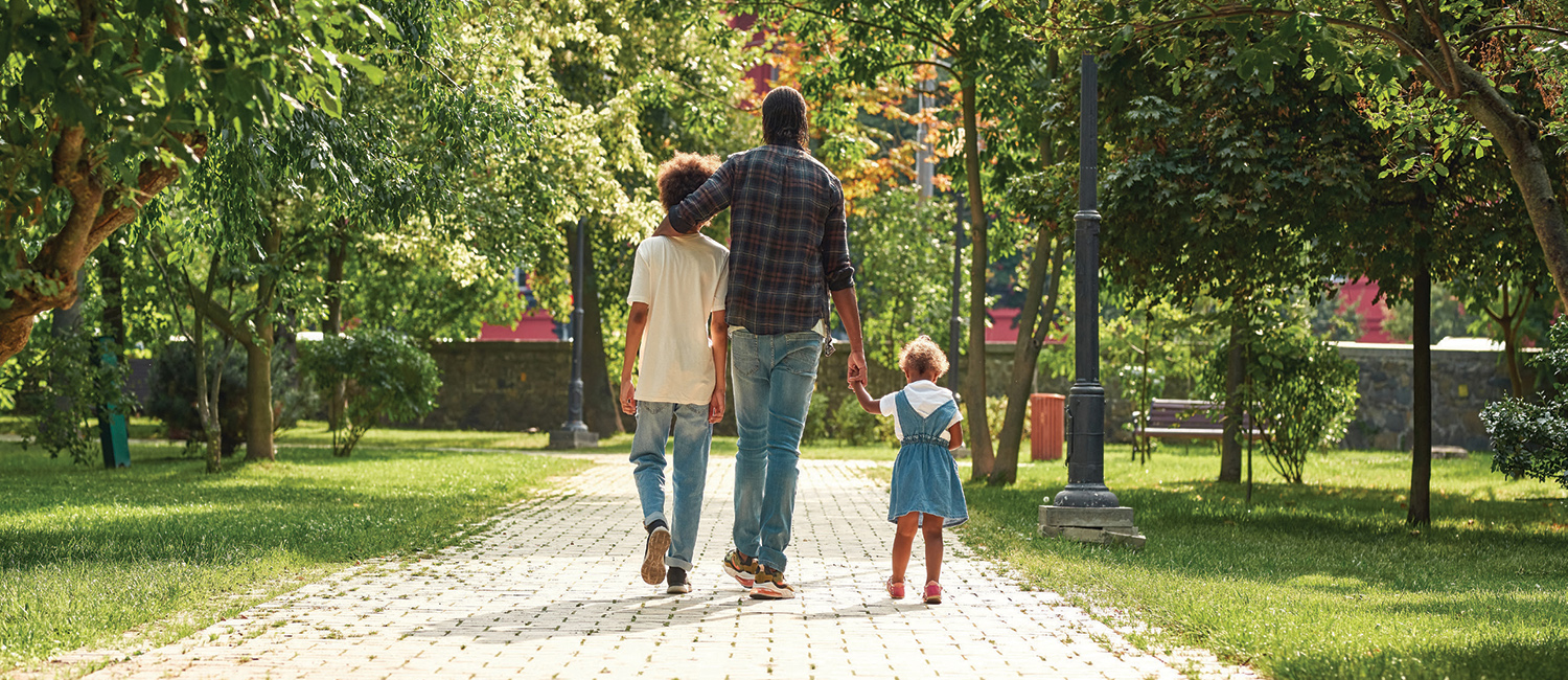 dad walking with two kids dad walking with two kids in a park